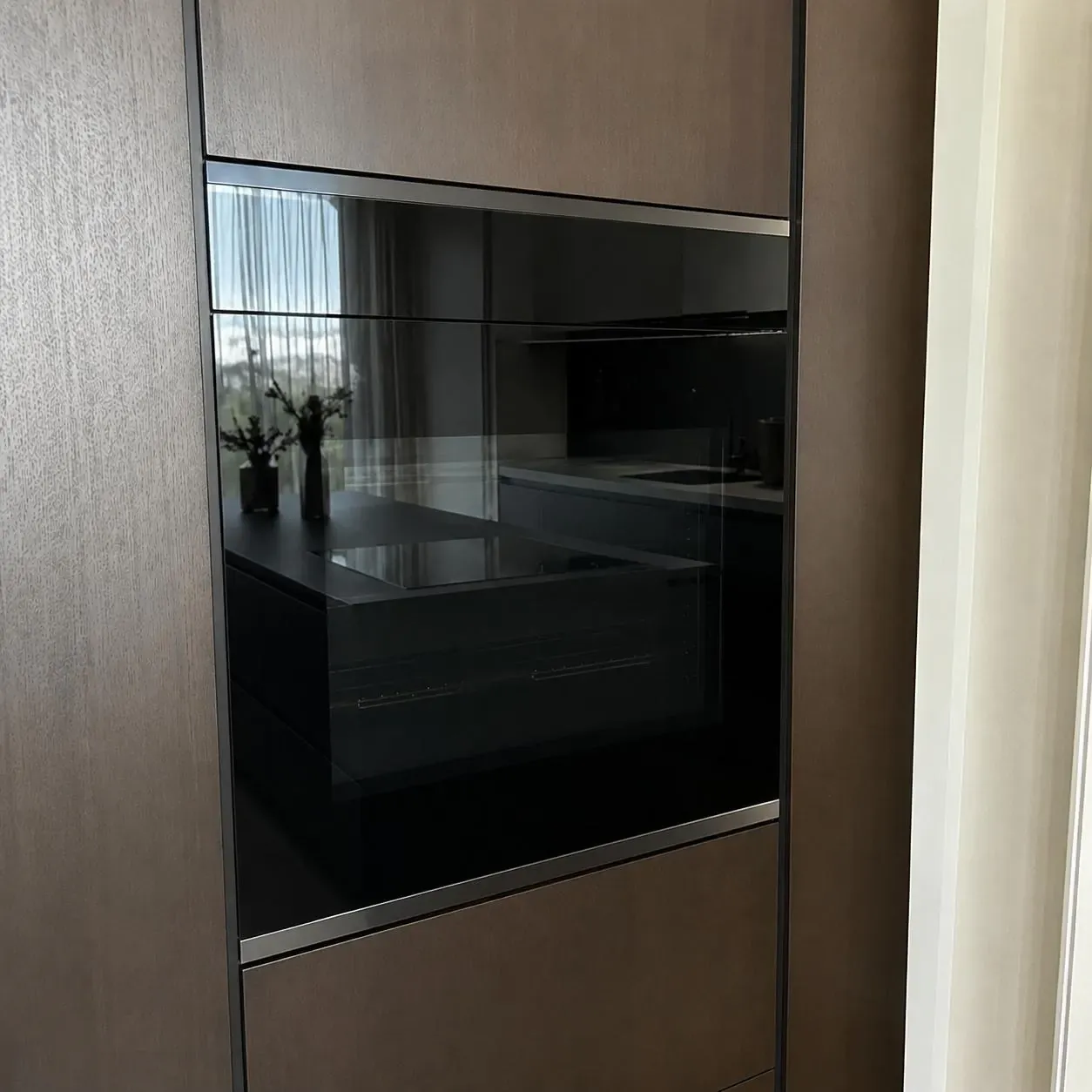 Minimalist dark-glass built-in wall oven in a high-end kitchen