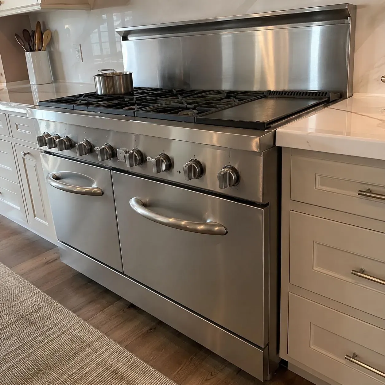 Commercial-style stainless range with bold tubular handles and a backguard